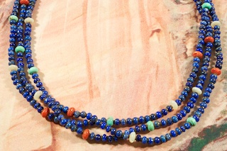 Stunning 3 Strand Necklace featuring Genuine Blue Lapis, Mother of Pearl, Red Jasper and Turquoise. Olive Shell Heishi Spacers. Sterling Silver Extender, Cones and Clasp. Created by Santo Domingo Artist Lester Abeyta. Lester Abeyta (Santo Domingo Pueblo) won first place in the Jewelry/Lapidary category at the IACA 2011 artist of the year awards. Lester is well known for his traditional stone and shell jewelry. His work is a reflection of the ancient techniques and styles of the Santo Domingo People, yet is fashionable in today's contemporary world. His parents, Richard and Delia Abeyta, taught Lester from an early age both the traditional and contemporary methods of lapidary art. All of his jewelry is hand made from raw materials utilizing both lapidary techniques.